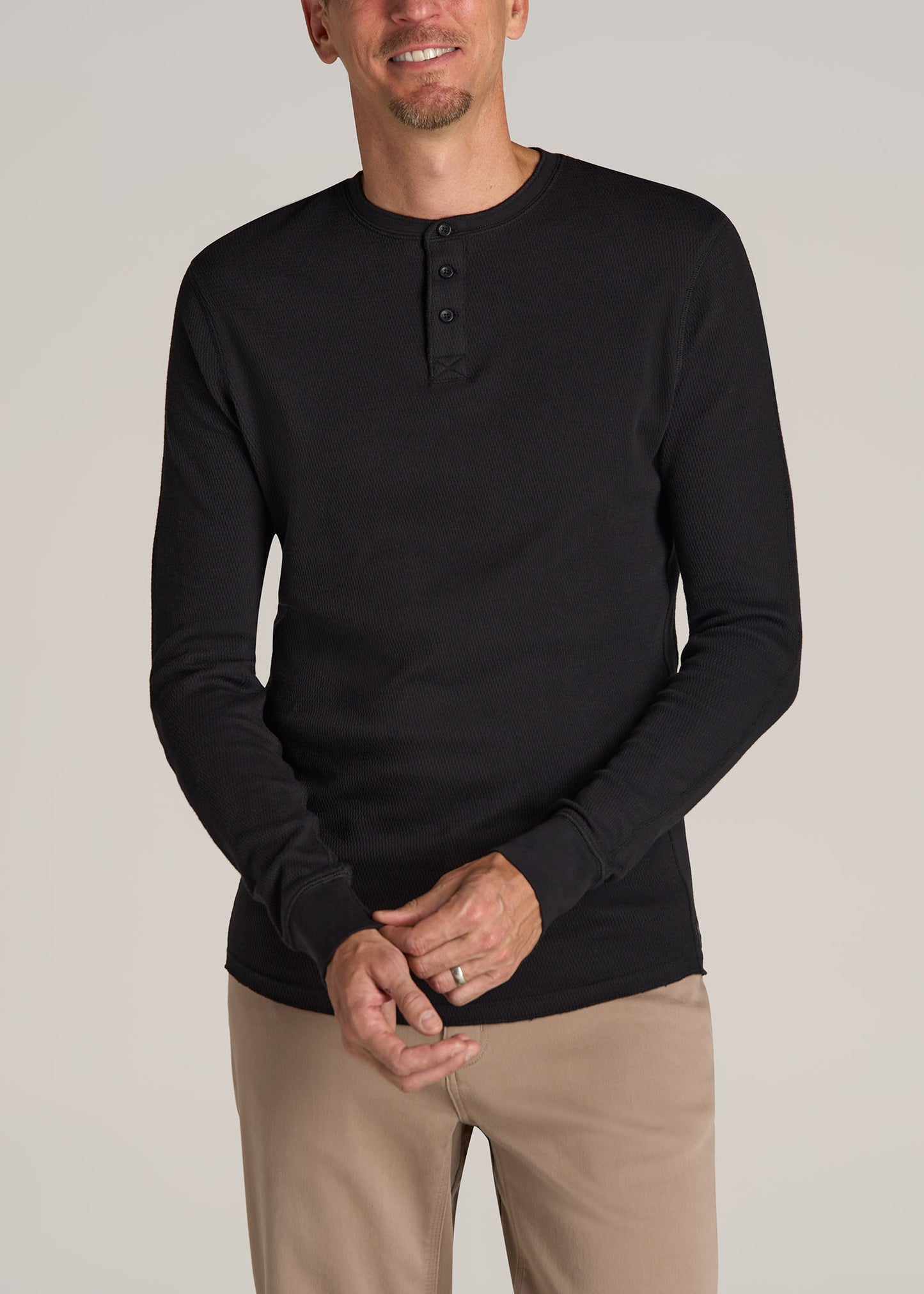 A tall man wearing American Tall's Double Honeycomb Thermal Long-Sleeve Henley Shirt for Tall Men in Black