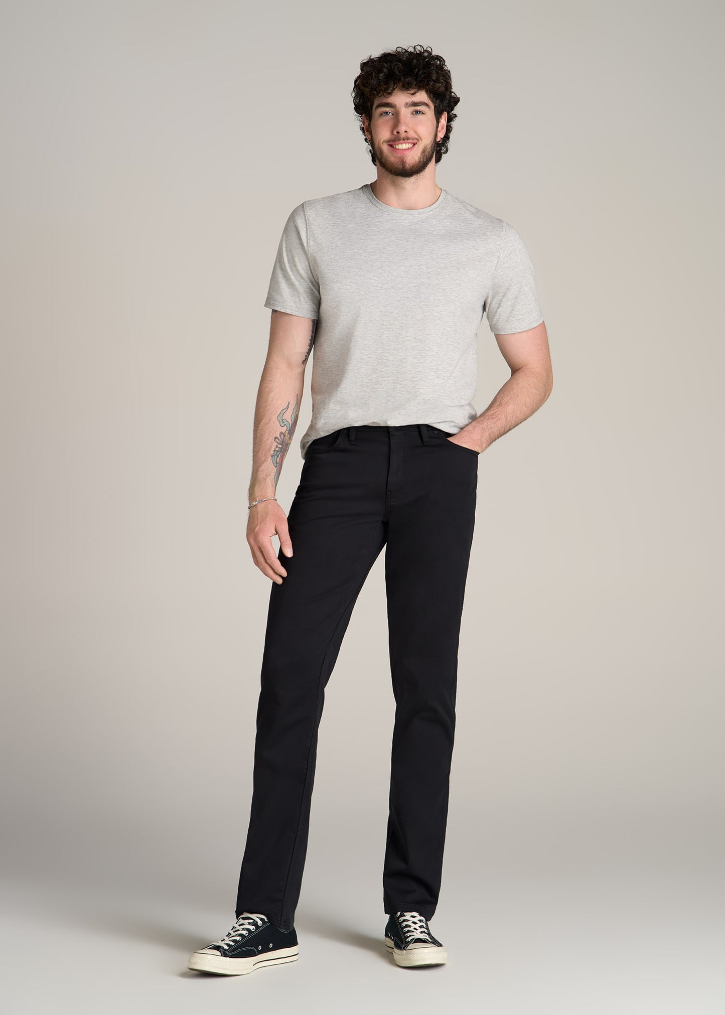 A tall man wearing American Tall's Everyday Comfort 5-Pocket TAPERED-FIT Pant for Tall Men in Black