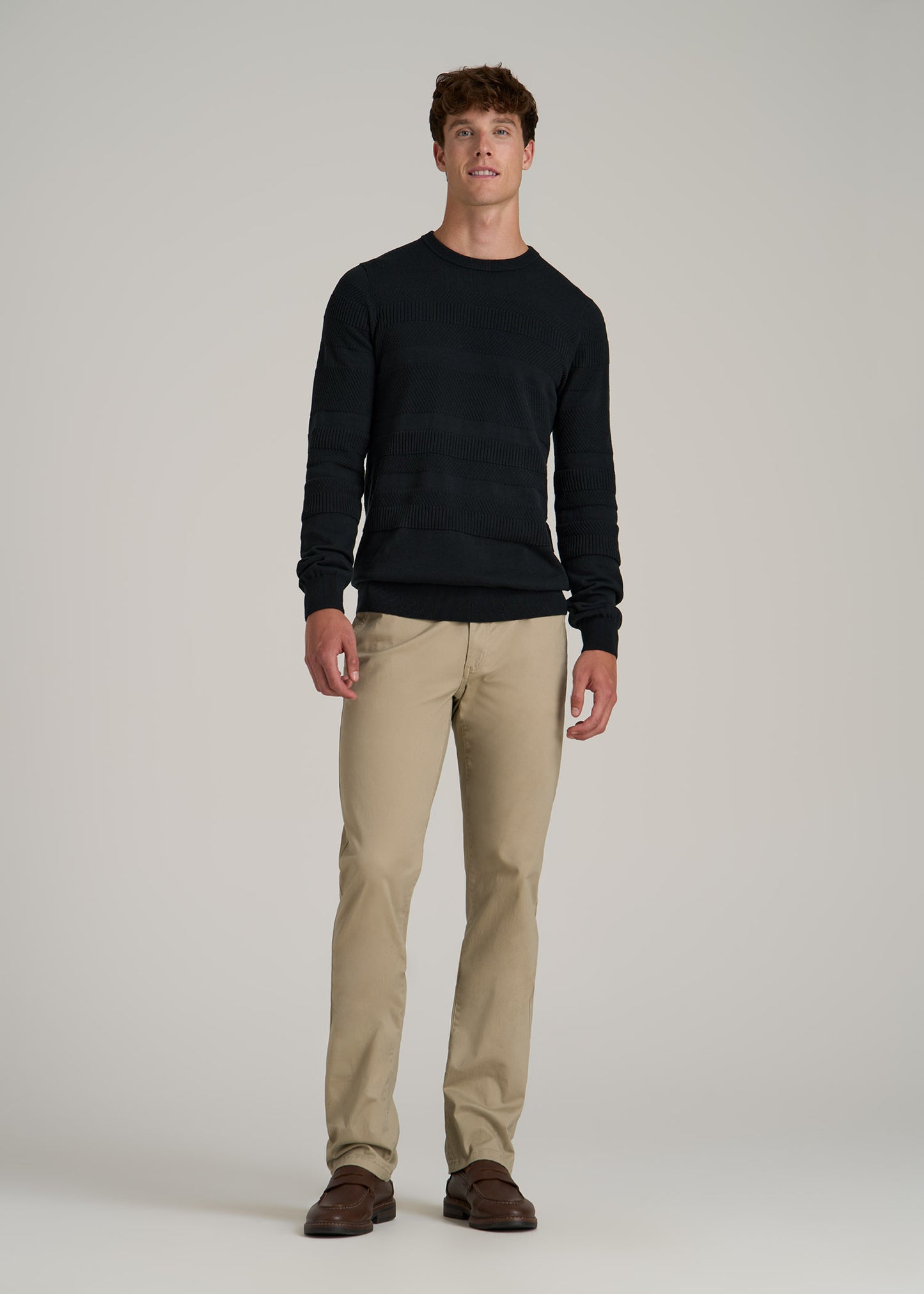 A tall man wearing American Tall's Minimalist Embossed Knit Sweater for Tall Men in Midnight Green