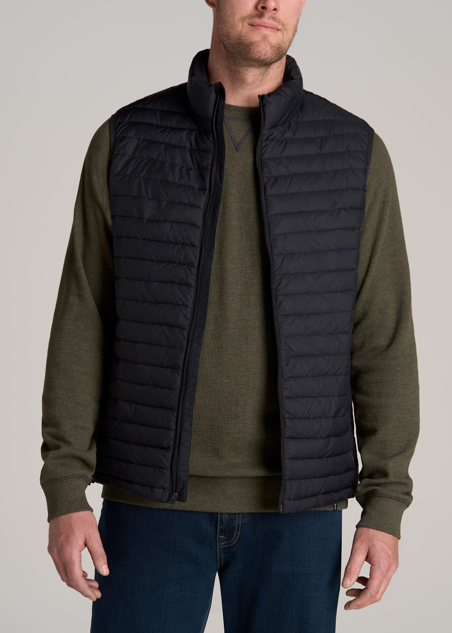 A tall man wearing American Tall's Tall Men's Packable Puffer Vest in Black