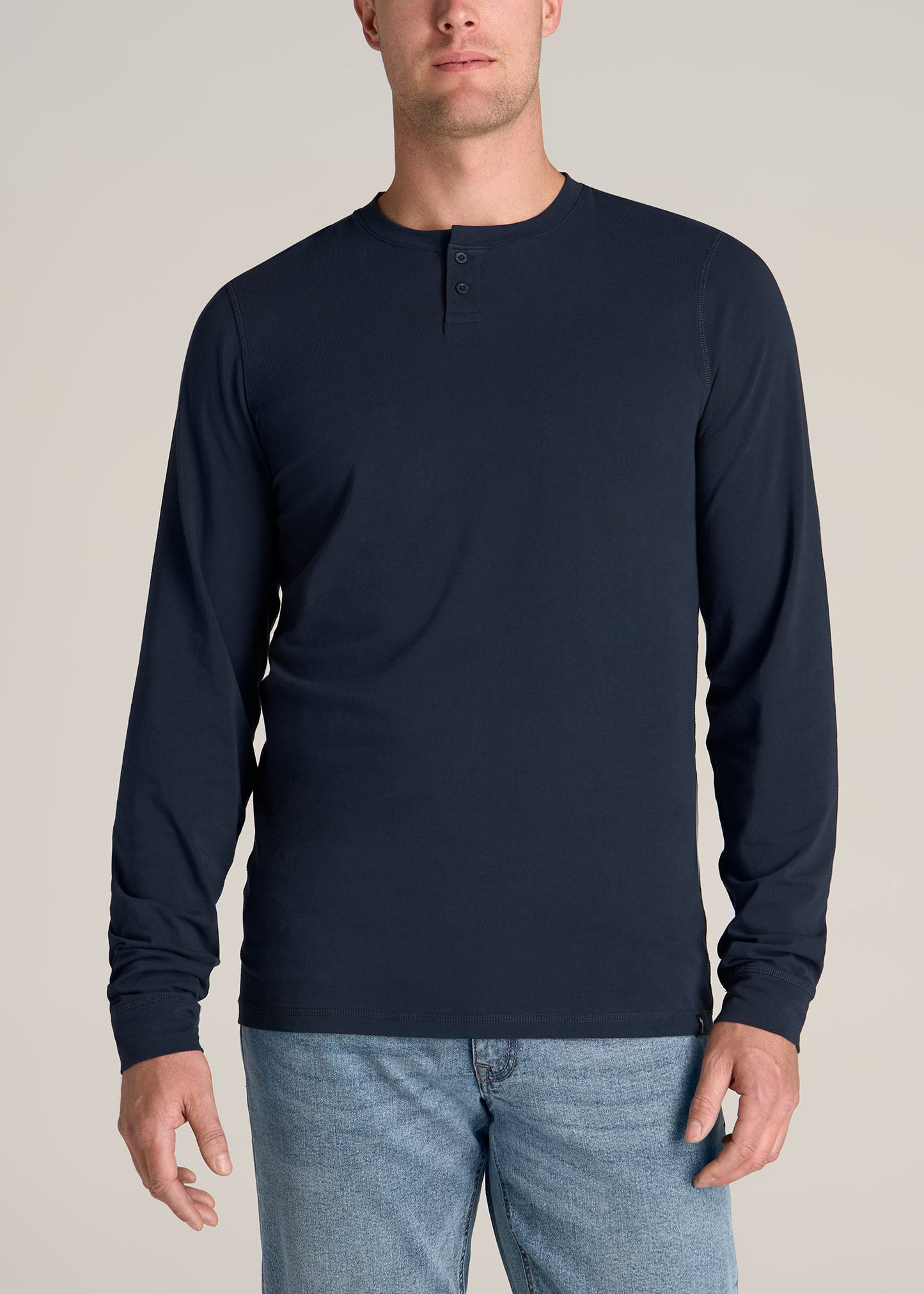 A tall man wearing American Tall's Pima Stretch Knit Henley Shirt for Tall Men in Evening Blue