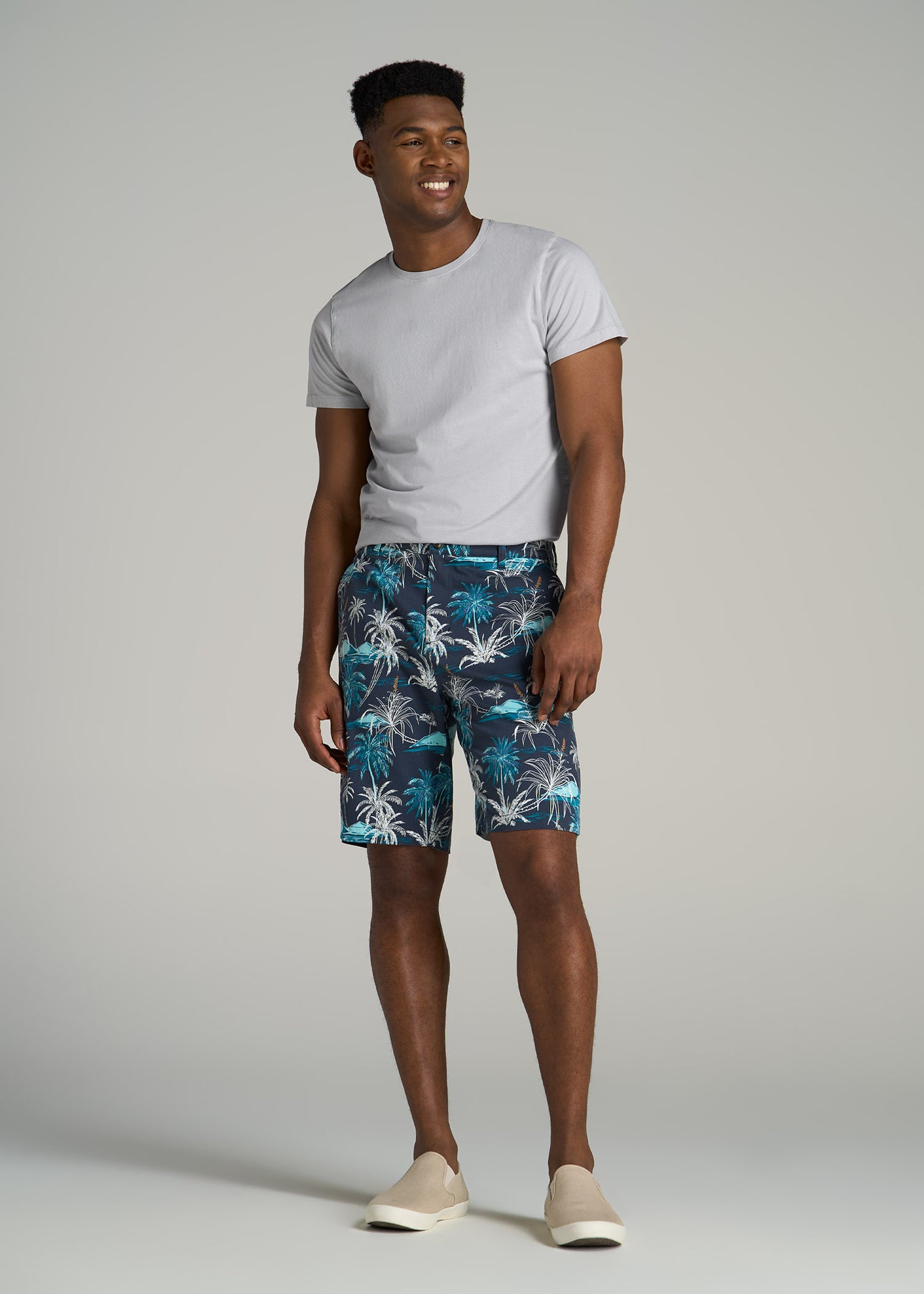 A tall man wearing American Tall's Printed Stretch Cotton Shorts for Tall Men in Blue and White Palms.