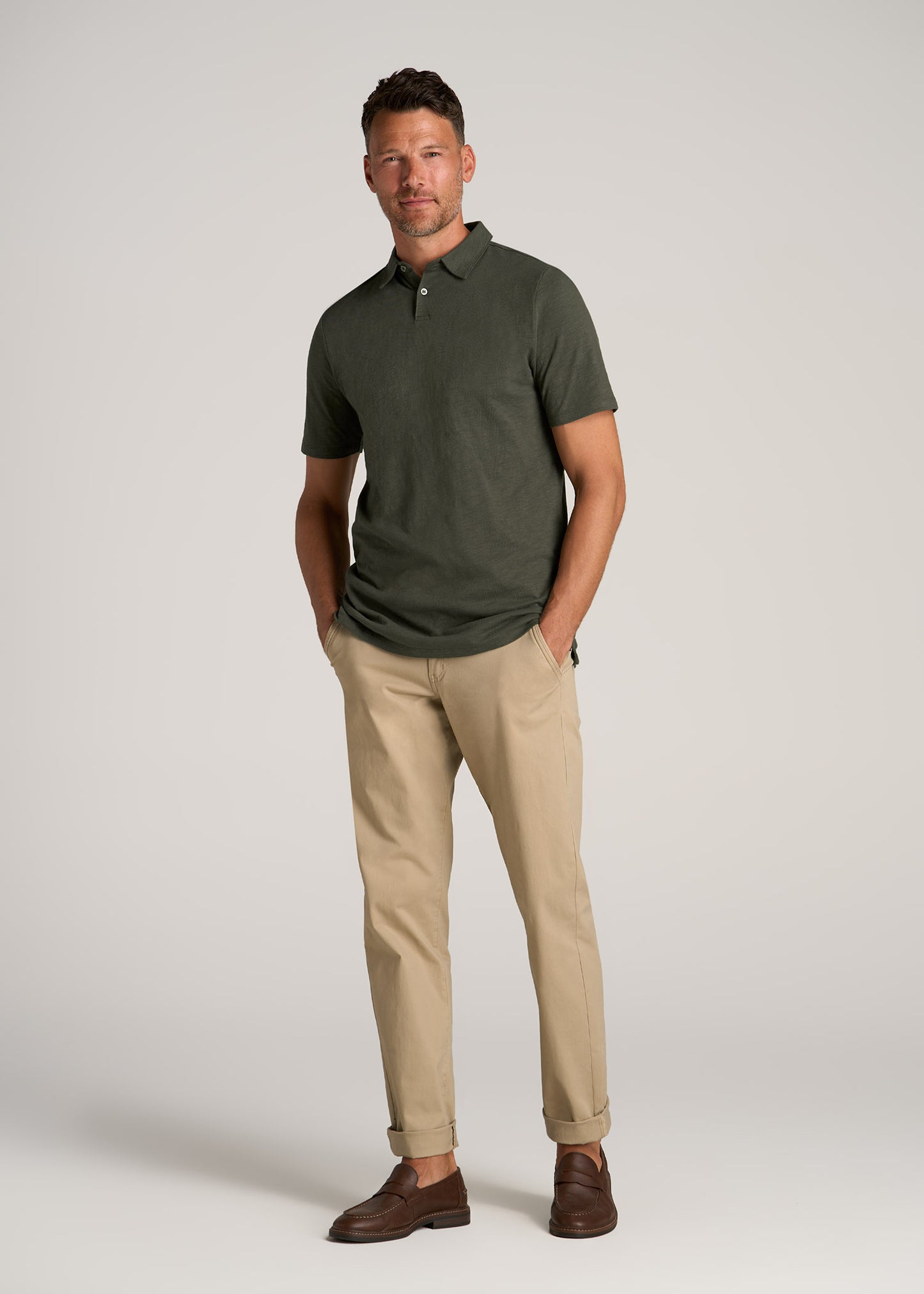 A tall man wearing American Tall's Slub Self Collar Polo in Dark Olive Green and
Carman Tapered Chinos in Desert Khaki.