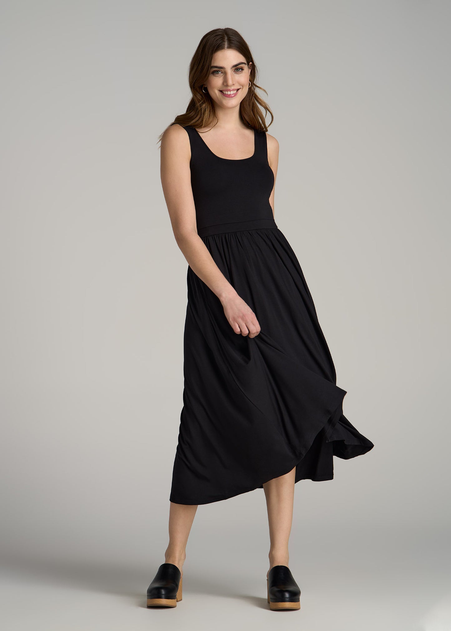 A tall woman wearing American Tall's Jersey Tank Dress with Pockets for Tall Women in Black