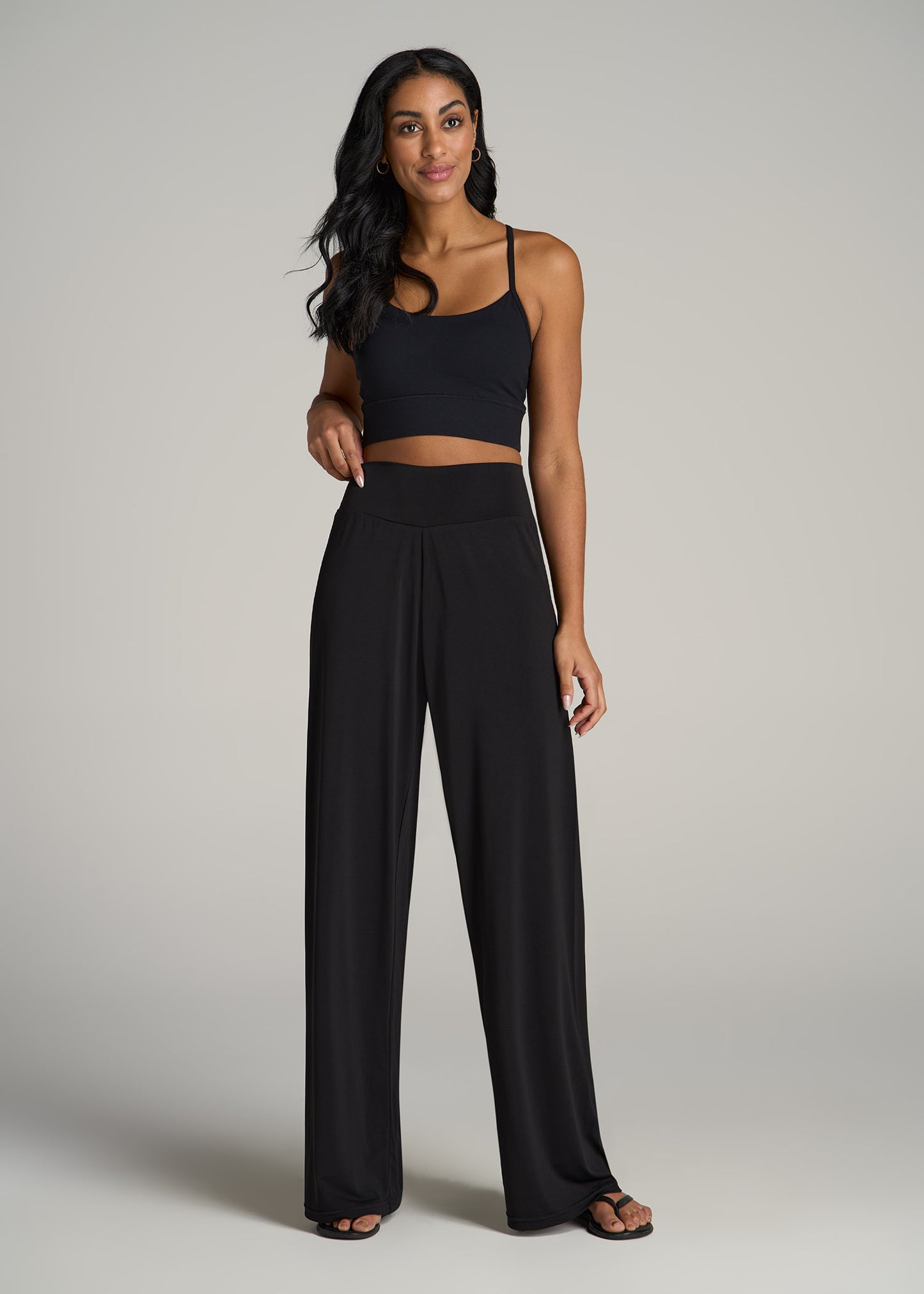 A tall woman wearing American Tall's Pull On Breezy Wide Leg Pants for Tall Women and a black crop top.