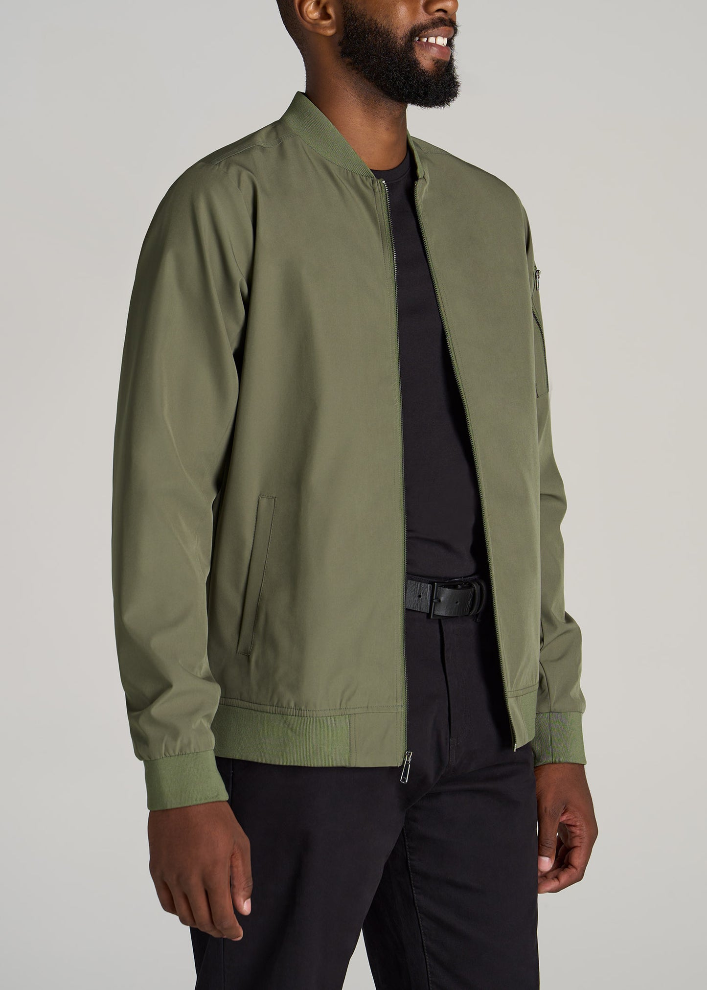 A tall slim man wearing American Tall's Bomber Jacket in an olive color.