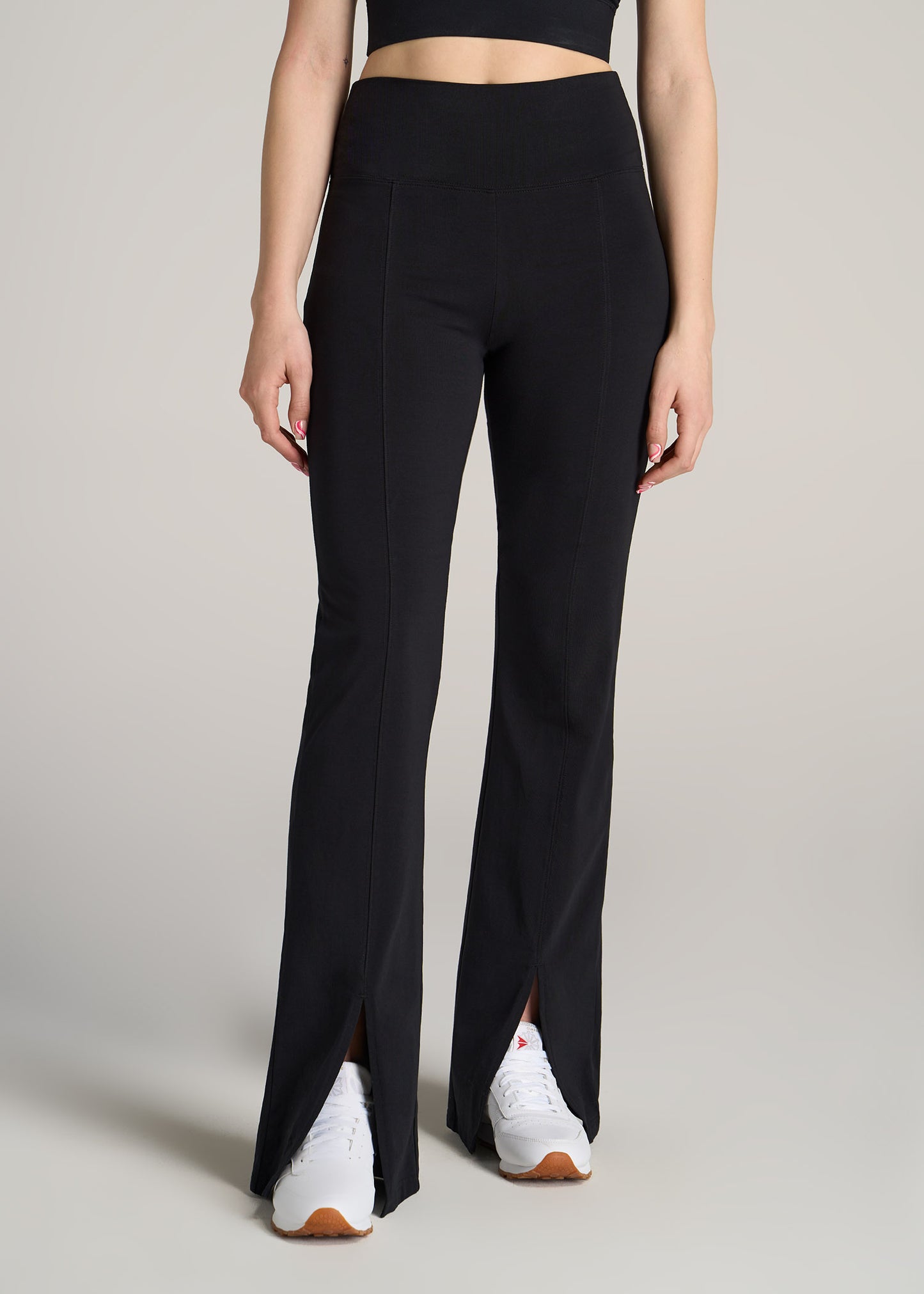 A tall woman wearing American Tall's High Rise Split Flare Cotton Legging in Black.