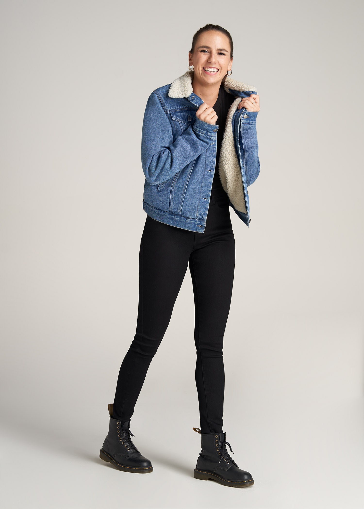 A tall woman wearing American Tall's Sherpa Denim Jacket in Stonewash Blue.