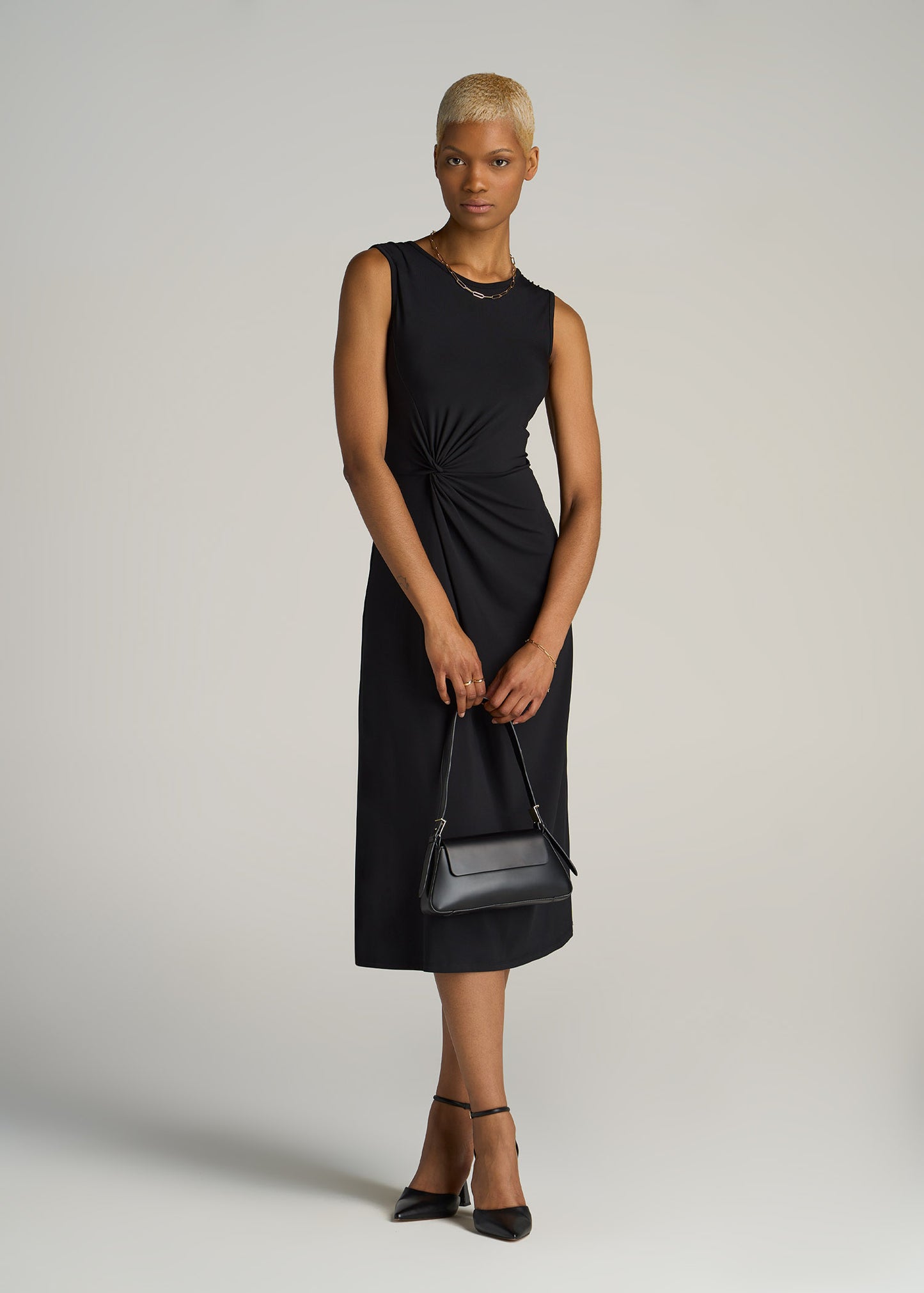 A tall woman wearing American Tall's Sleeveless Knot Front Dress for Tall Women in Black