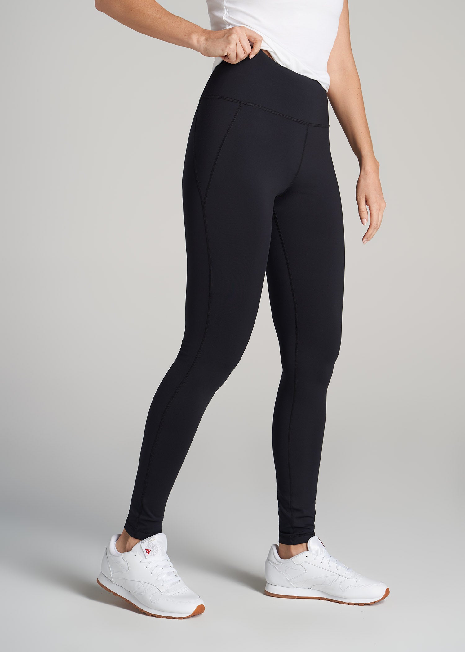 A tall woman wearing American Tall's Fleece-Lined Legging in black.